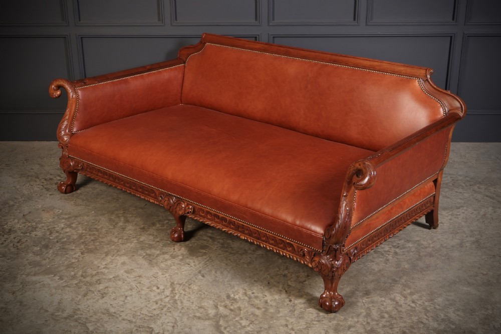 A three-piece lounge suite comprising a three-seater sofa and two matching armchairs upholstered in chestnut brown leather with carved mahogany frames and claw and ball feet. View XVI