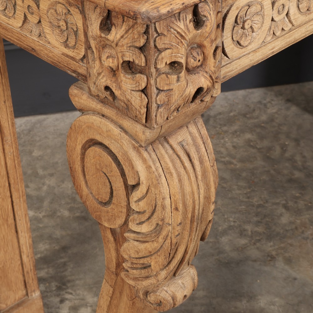 A carved bleached oak console table featuring a raised back gallery, rosette carved frieze, and sculptural monopodium legs terminating in lion paw feet. View III