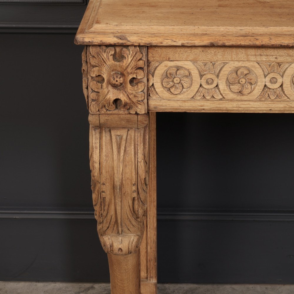 A carved bleached oak console table featuring a raised back gallery, rosette carved frieze, and sculptural monopodium legs terminating in lion paw feet. View VIII
