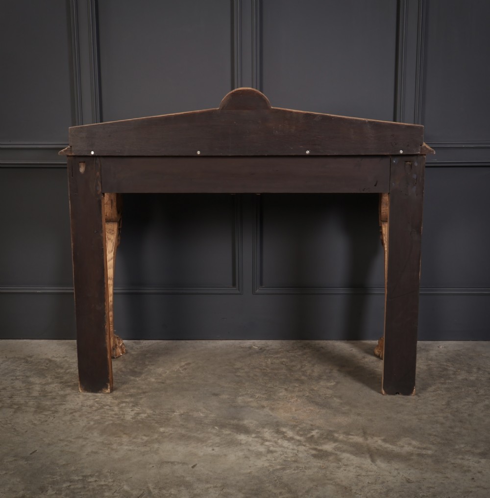 A carved bleached oak console table featuring a raised back gallery, rosette carved frieze, and sculptural monopodium legs terminating in lion paw feet. View XIV