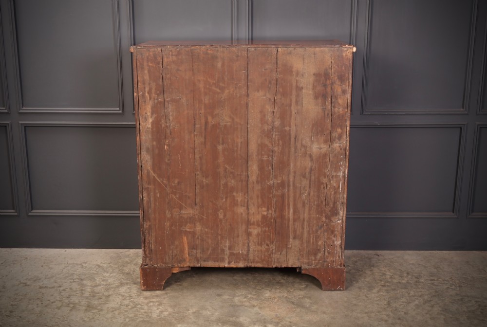 A Georgian walnut chest of drawers with figured grain, brass drop handles, bone escutcheons, and bracket feet. View VIII