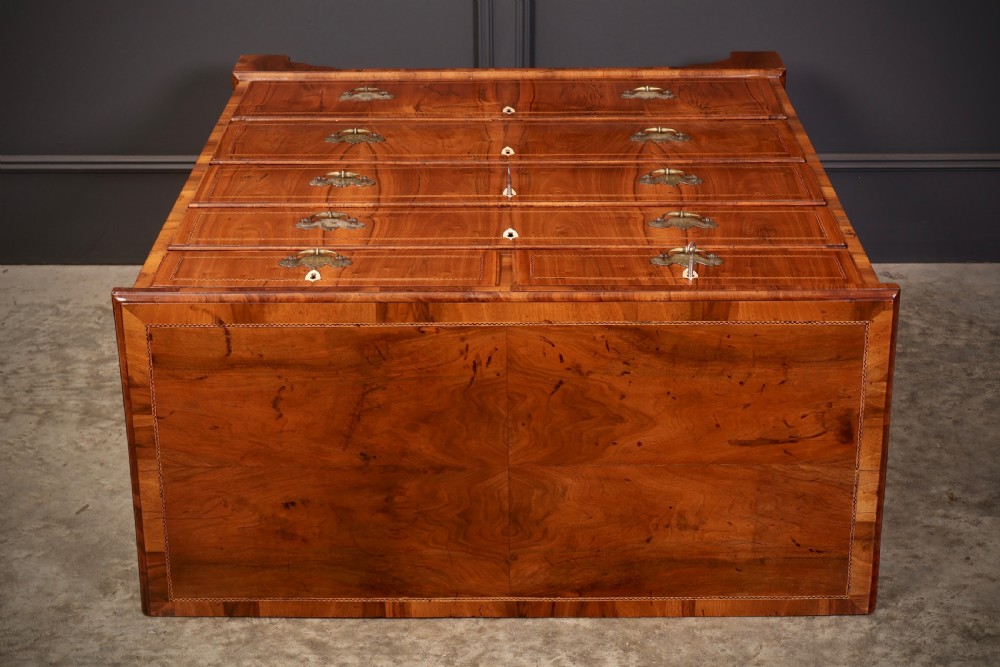 A Georgian walnut chest of drawers with figured grain, brass drop handles, bone escutcheons, and bracket feet. View IX