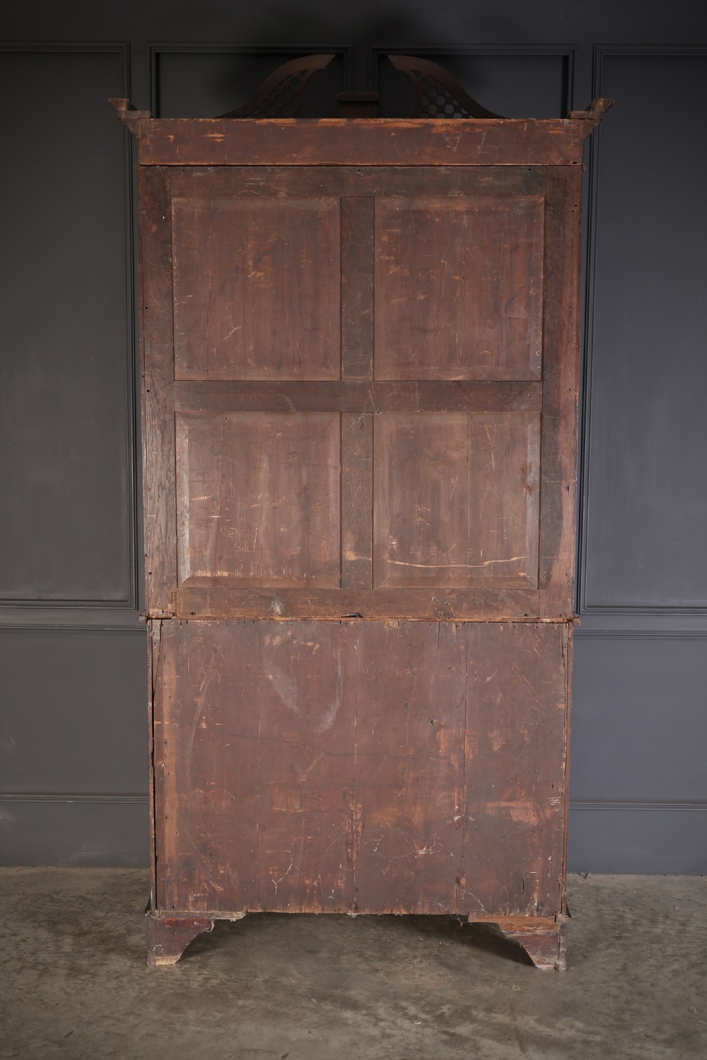 A tall Georgian mahogany bookcase featuring a pierced fretwork pediment, two upper glazed doors with intricate geometric glazing bars, and a lower serpentine chest of three drawers adorned with detailed floral marquetry inlays and brass handles. View XV