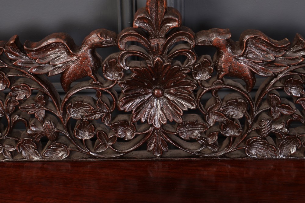 A carved dark padauk wood console table featuring openwork floral fretwork, a raised gallery back, and carved cabriole legs. View IV