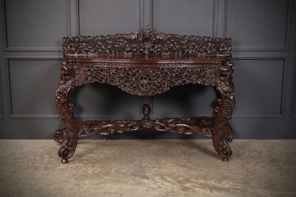 A carved dark padauk wood console table featuring openwork floral fretwork, a raised gallery back, and carved cabriole legs. View V