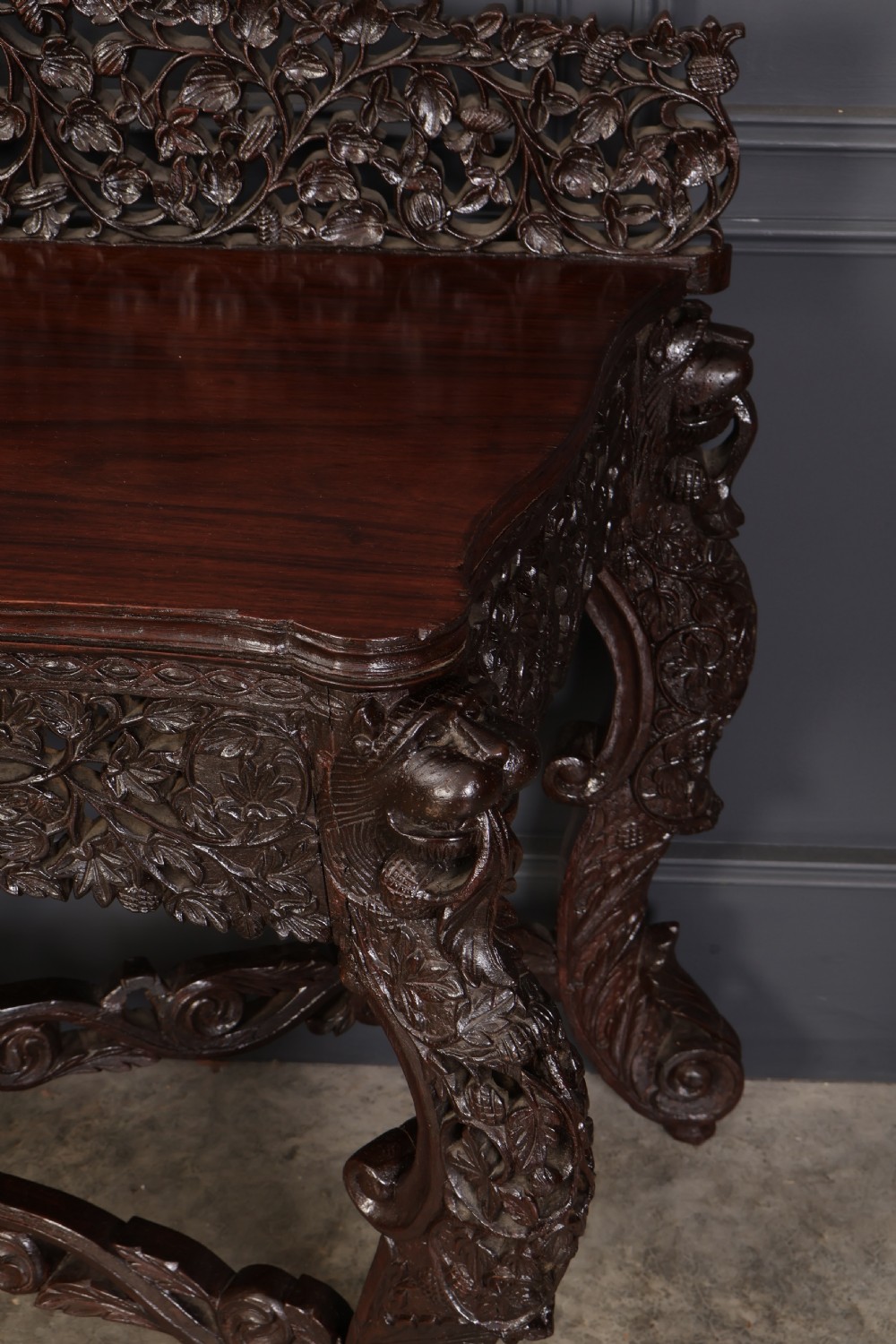 A carved dark padauk wood console table featuring openwork floral fretwork, a raised gallery back, and carved cabriole legs. View VII