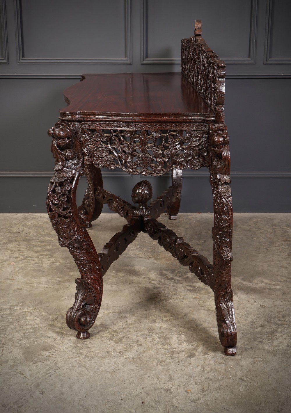 A carved dark padauk wood console table featuring openwork floral fretwork, a raised gallery back, and carved cabriole legs. View X