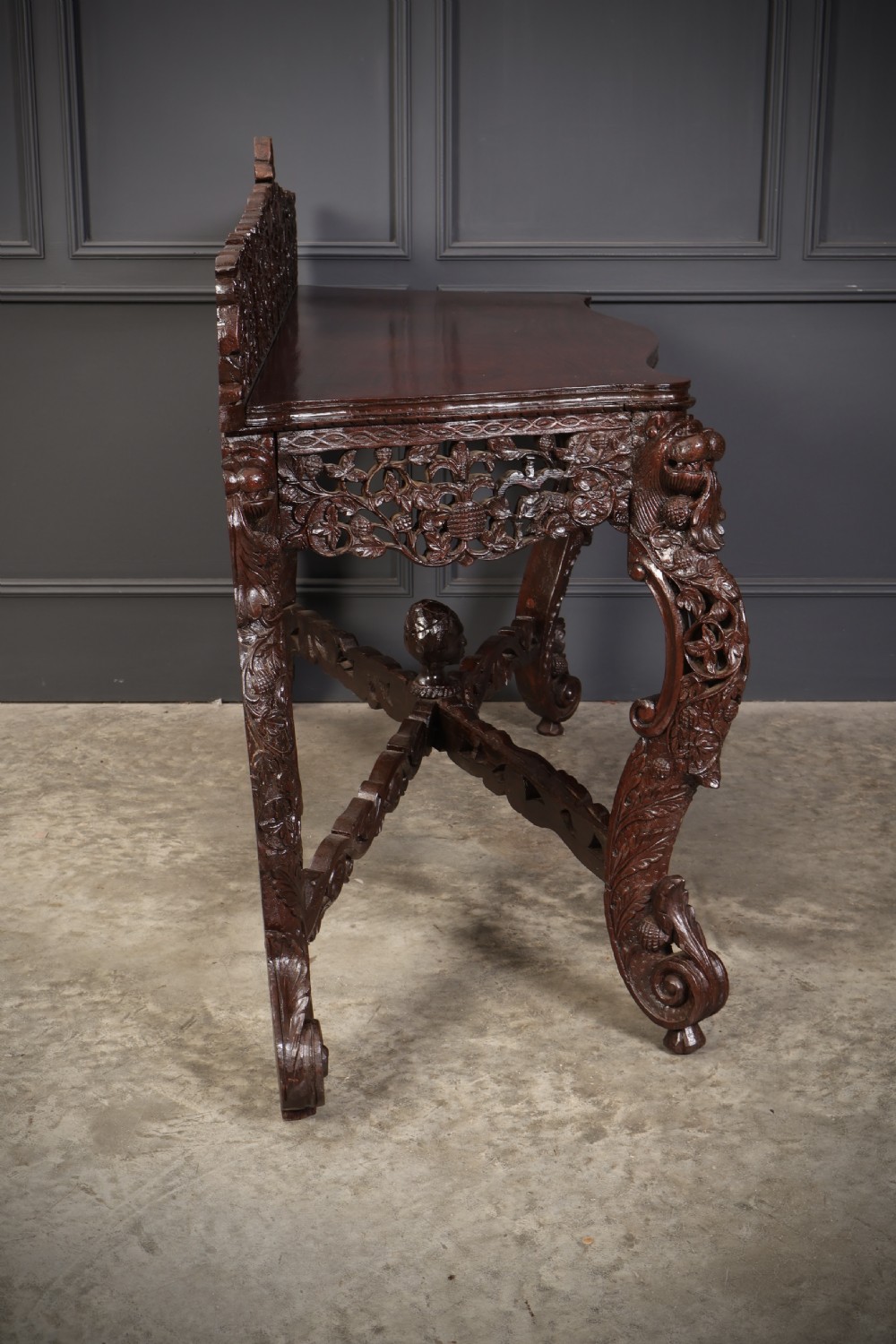 A carved dark padauk wood console table featuring openwork floral fretwork, a raised gallery back, and carved cabriole legs. View XII