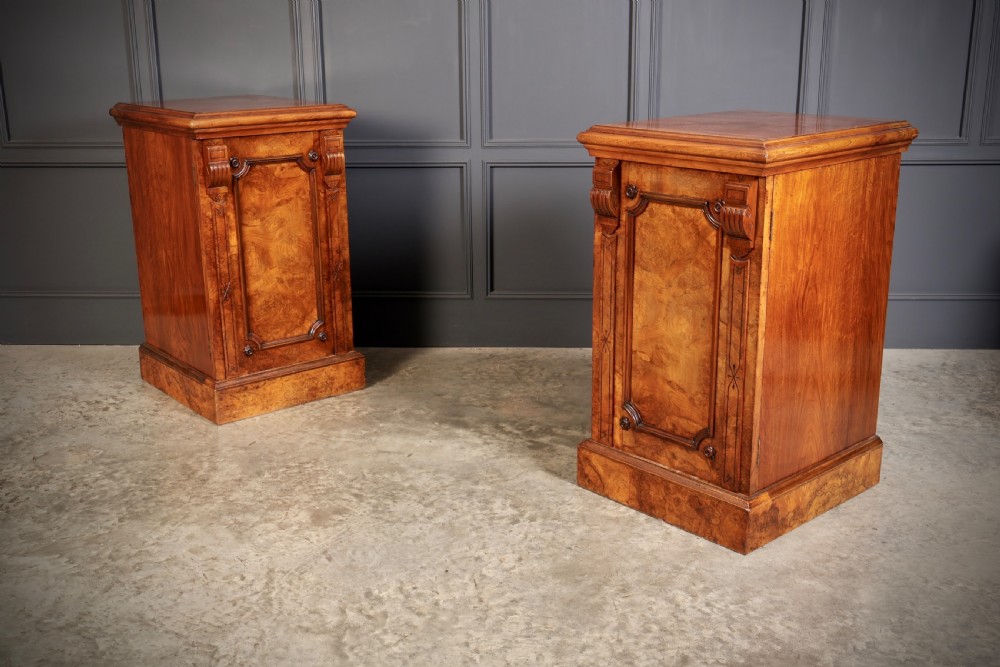 A matching pair of Victorian figured walnut pedestal cabinets featuring carved corbels, panelled doors with decorative line inlay, and sturdy plinth bases. View III