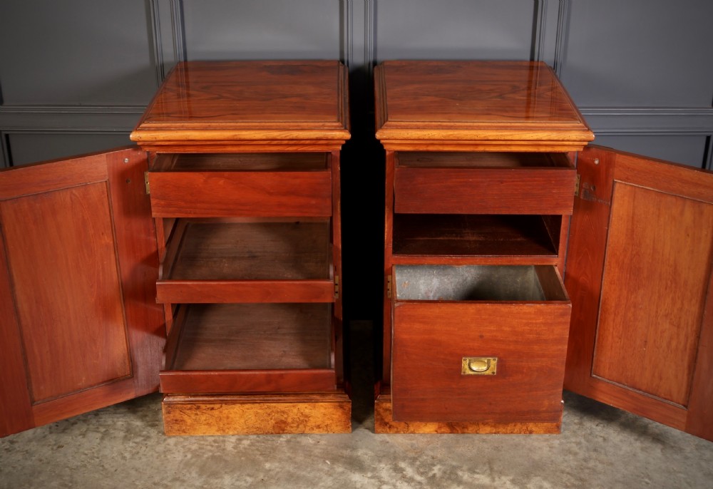 A matching pair of Victorian figured walnut pedestal cabinets featuring carved corbels, panelled doors with decorative line inlay, and sturdy plinth bases. View VI