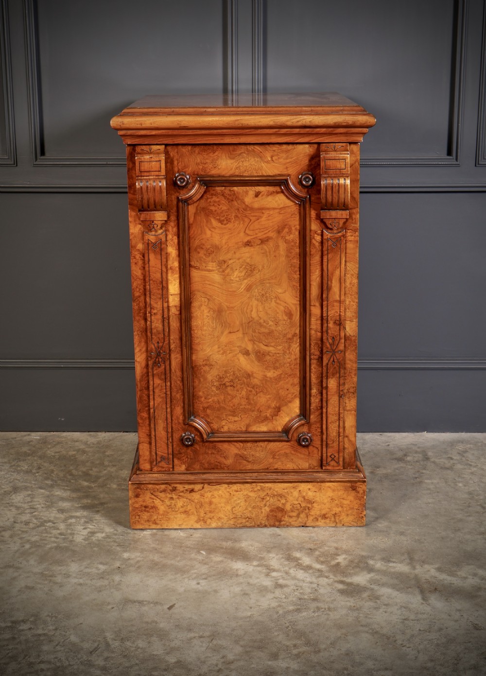 A matching pair of Victorian figured walnut pedestal cabinets featuring carved corbels, panelled doors with decorative line inlay, and sturdy plinth bases. View VIII
