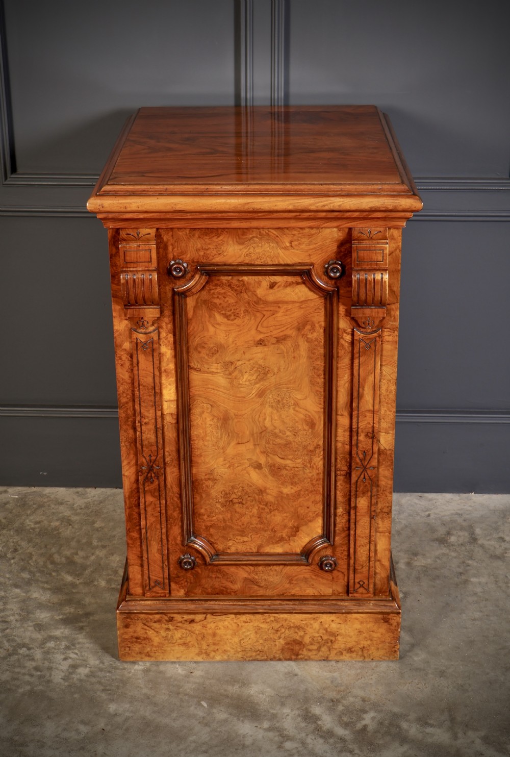 A matching pair of Victorian figured walnut pedestal cabinets featuring carved corbels, panelled doors with decorative line inlay, and sturdy plinth bases. View IX