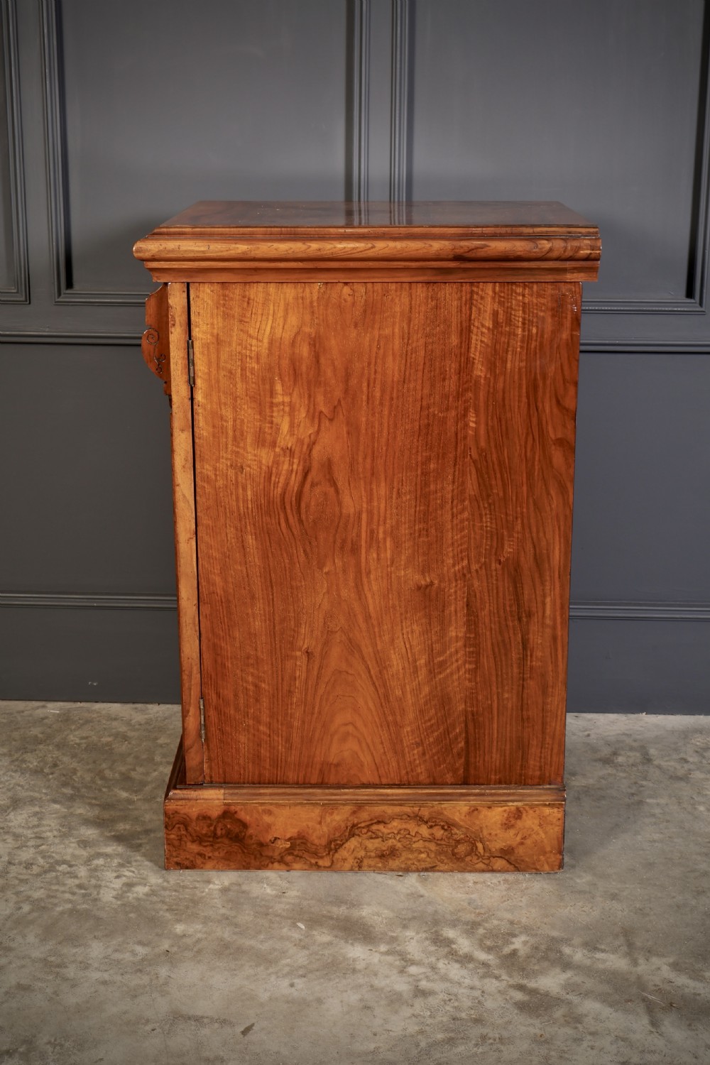 A matching pair of Victorian figured walnut pedestal cabinets featuring carved corbels, panelled doors with decorative line inlay, and sturdy plinth bases. View XI
