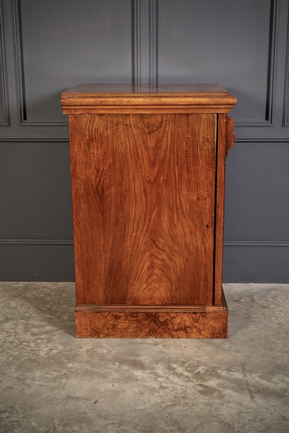 A matching pair of Victorian figured walnut pedestal cabinets featuring carved corbels, panelled doors with decorative line inlay, and sturdy plinth bases. View XIII