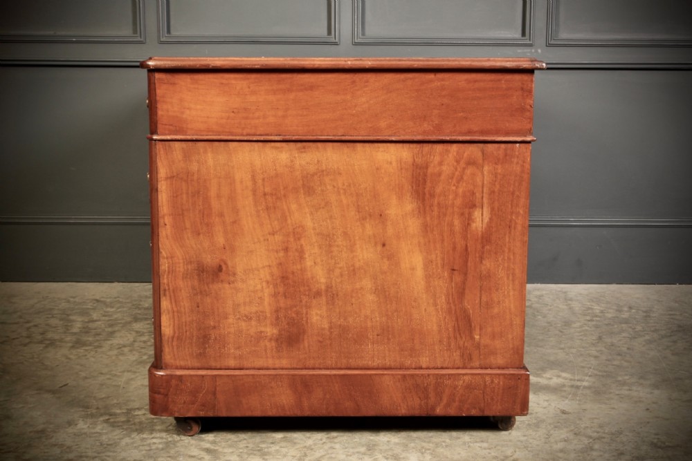 A nineteenth-century Victorian walnut pedestal desk featuring an inset green leather writing surface, twin drawer pedestals, and brass drop handles. View VIII