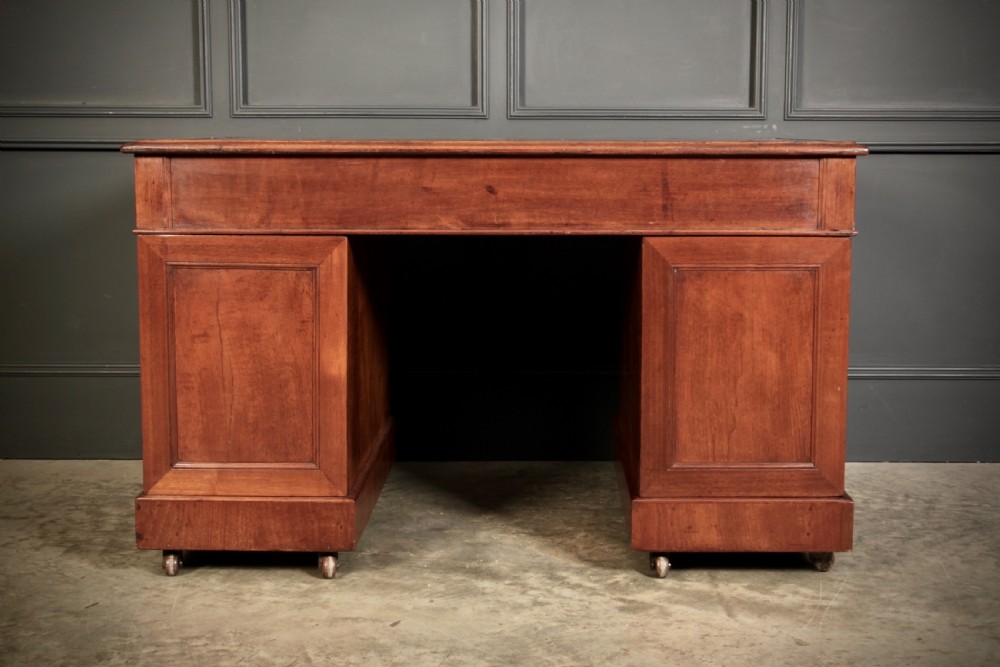 A nineteenth-century Victorian walnut pedestal desk featuring an inset green leather writing surface, twin drawer pedestals, and brass drop handles. View IX