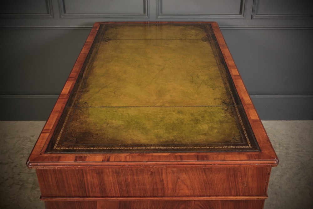 A nineteenth-century Victorian walnut pedestal desk featuring an inset green leather writing surface, twin drawer pedestals, and brass drop handles. View XI
