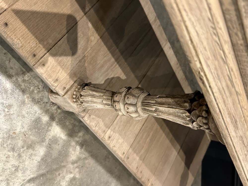 A long carved bleached oak potboard dresser base featuring relief carved drawer fronts, turned support legs, brass drop handles, and an open lower display shelf. View IV
