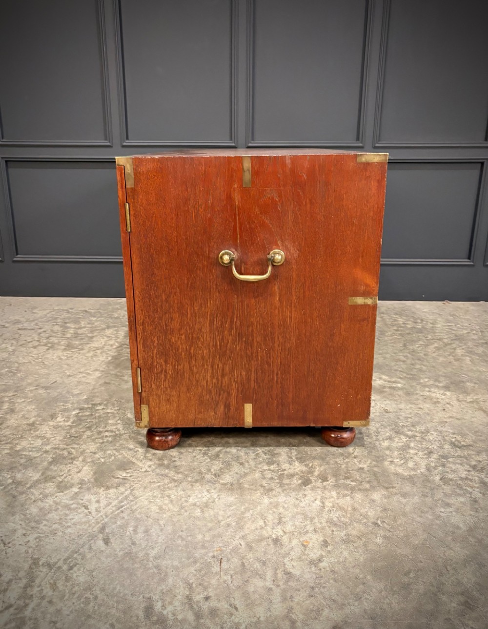 A low Victorian teak military campaign side cabinet featuring double panelled doors, brass corner mounts, brass side handles, and short turned feet. View X