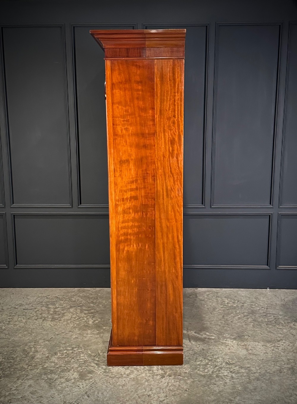 A Victorian mahogany double wardrobe featuring two arched panel doors with carved crest details, a flared top cornice, and a solid plinth base. View VIII