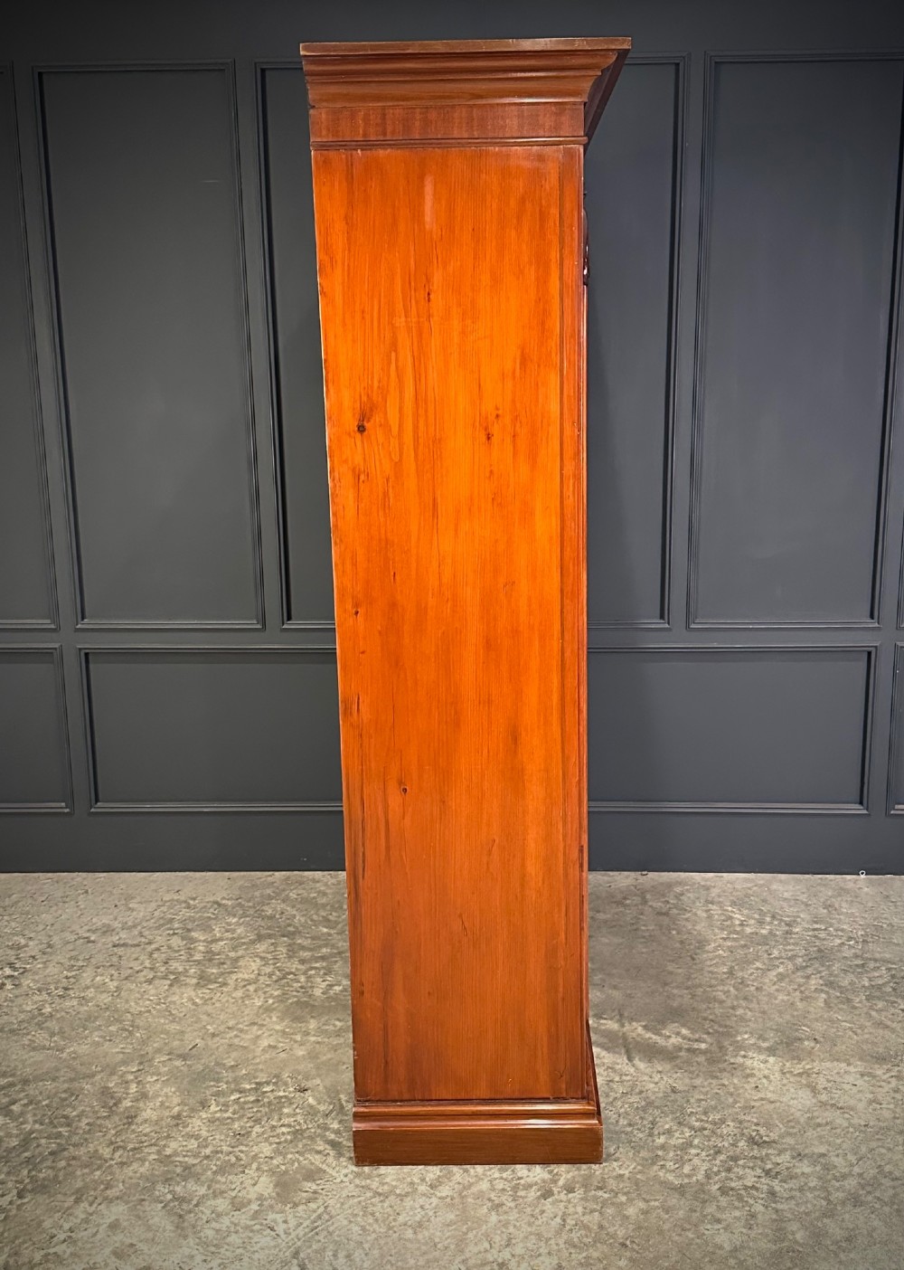 A Victorian mahogany double wardrobe featuring two arched panel doors with carved crest details, a flared top cornice, and a solid plinth base. View X