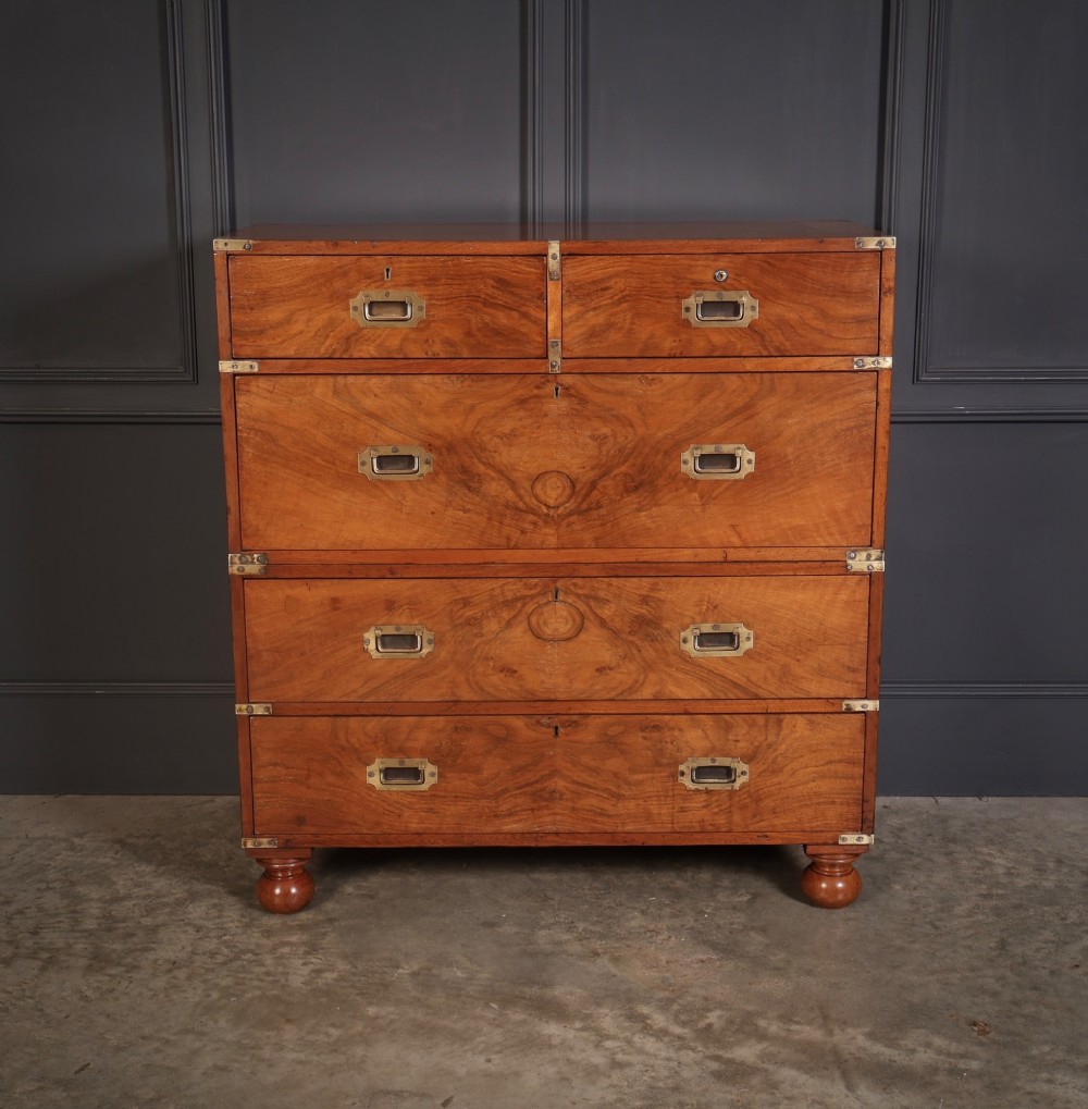 A Victorian figured walnut military campaign chest featuring two stackable sections, flush brass handles, brass corner strapping, and turned feet. View III