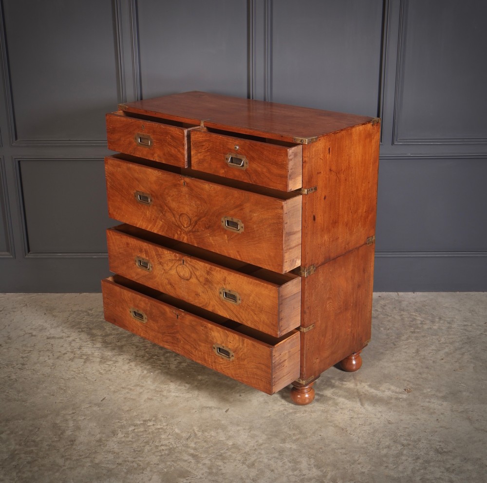 A Victorian figured walnut military campaign chest featuring two stackable sections, flush brass handles, brass corner strapping, and turned feet. View IX