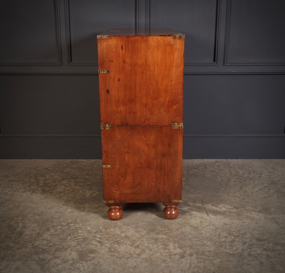 A Victorian figured walnut military campaign chest featuring two stackable sections, flush brass handles, brass corner strapping, and turned feet. View X