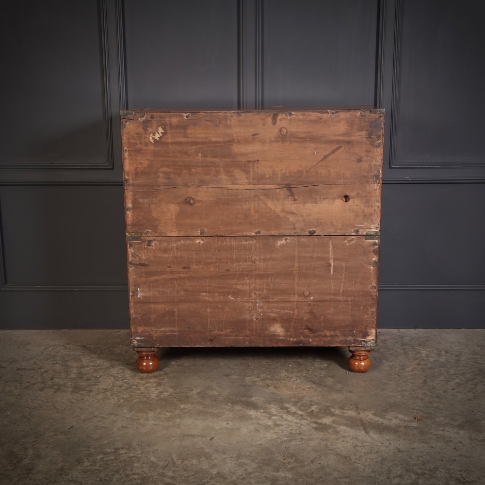 A Victorian figured walnut military campaign chest featuring two stackable sections, flush brass handles, brass corner strapping, and turned feet. View XI