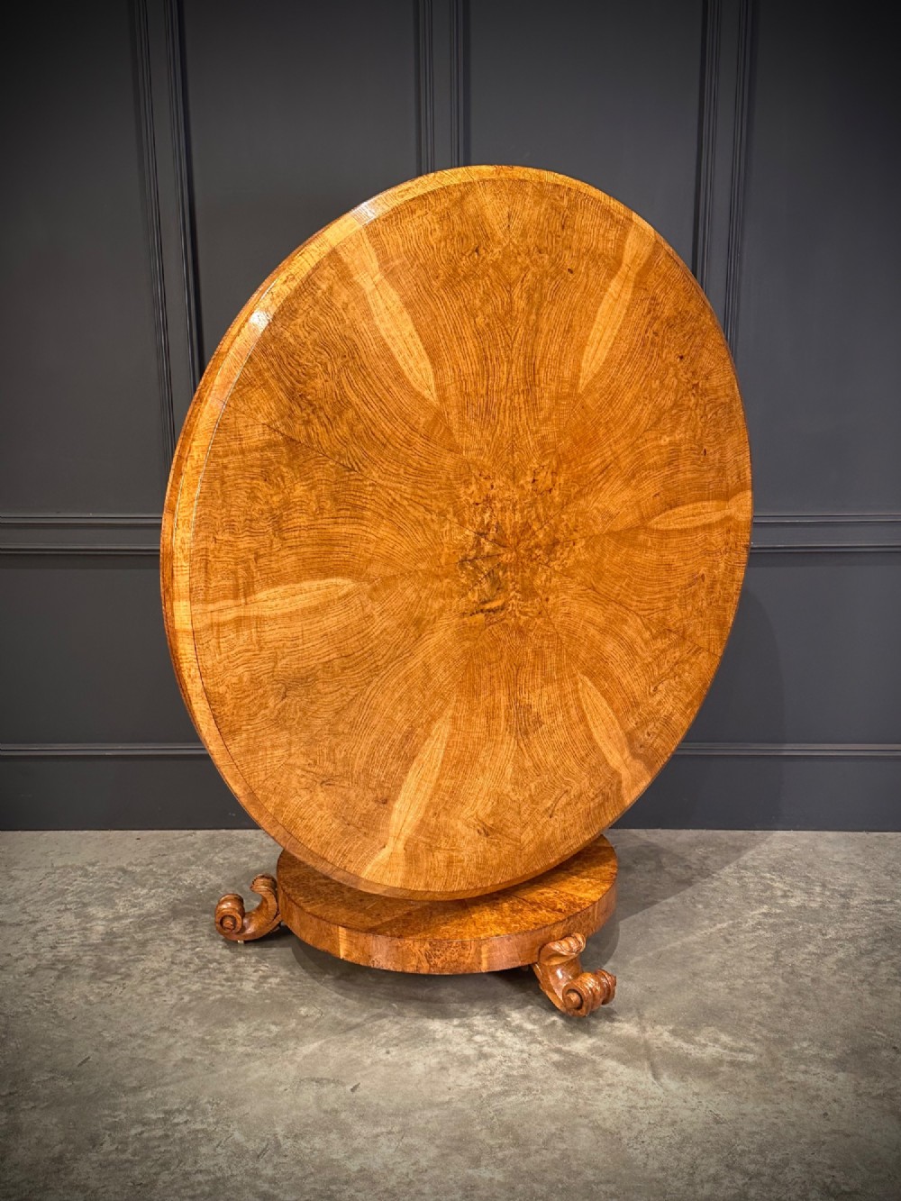 A round antique pollard oak breakfast table featuring a radial veneer pattern, faceted pedestal column, platform base, and four scroll feet. View II