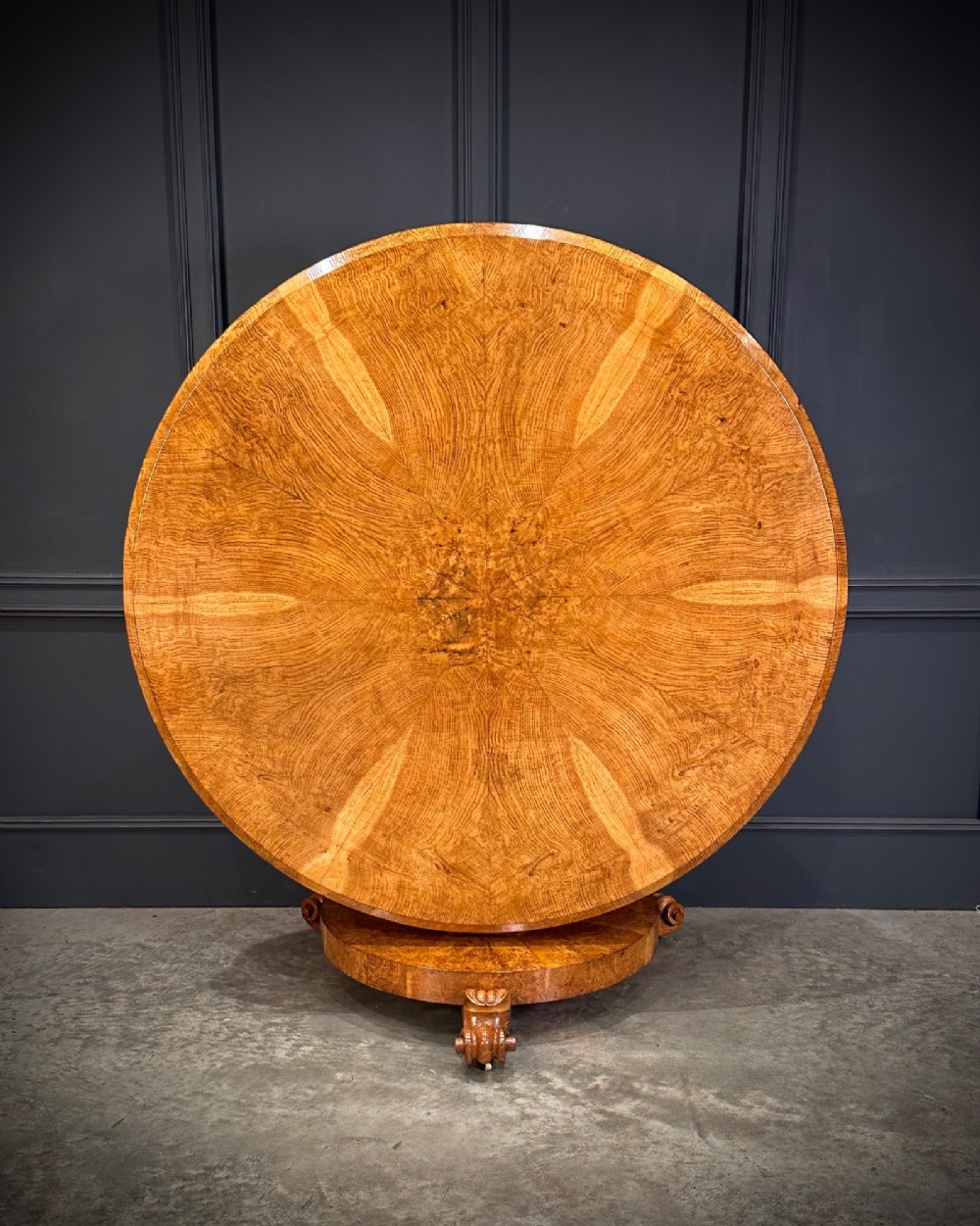 A round antique pollard oak breakfast table featuring a radial veneer pattern, faceted pedestal column, platform base, and four scroll feet. View III