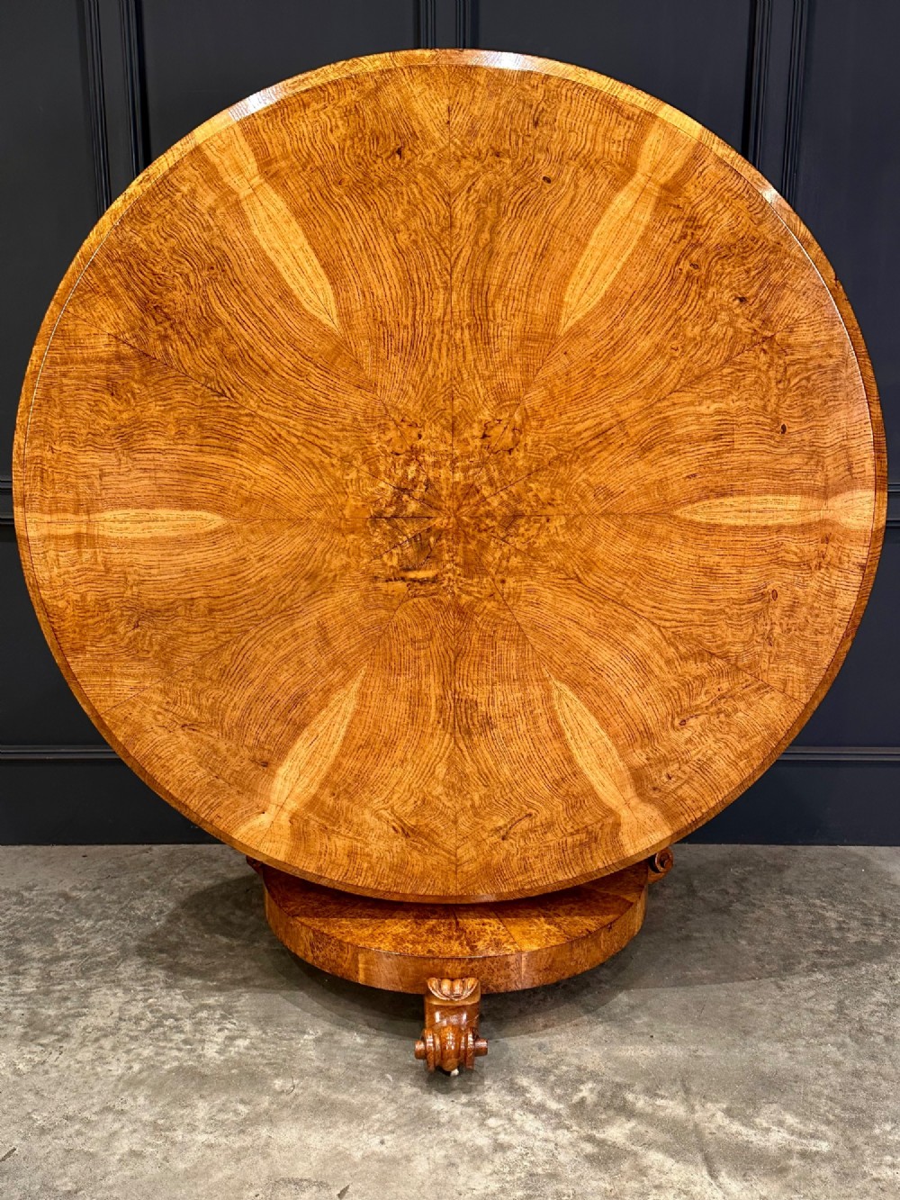 A round antique pollard oak breakfast table featuring a radial veneer pattern, faceted pedestal column, platform base, and four scroll feet. View IV