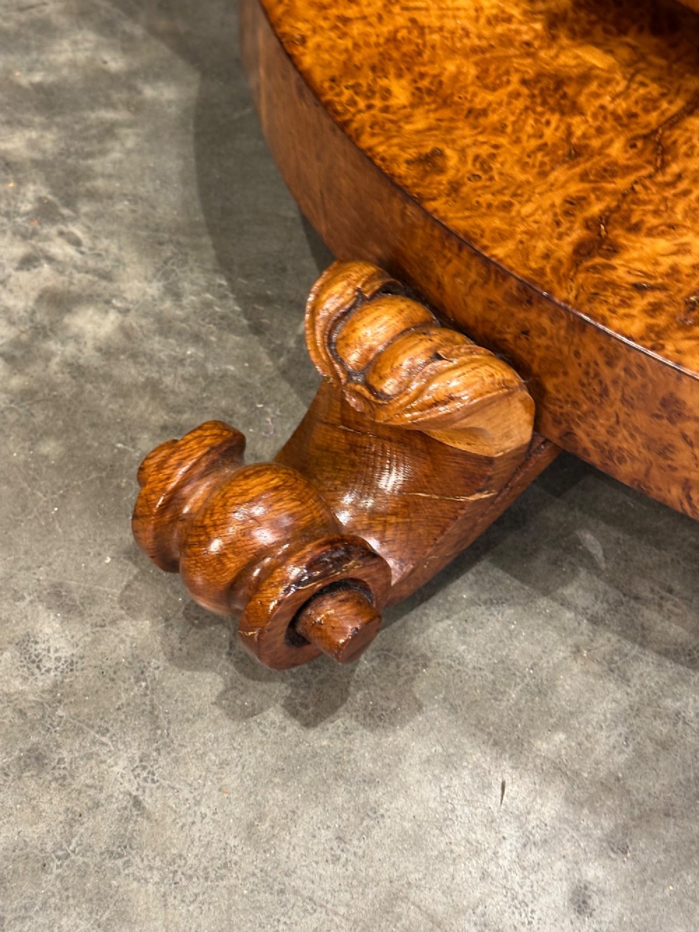 A round antique pollard oak breakfast table featuring a radial veneer pattern, faceted pedestal column, platform base, and four scroll feet. View VI