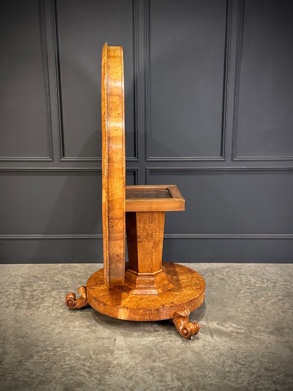 A round antique pollard oak breakfast table featuring a radial veneer pattern, faceted pedestal column, platform base, and four scroll feet. View VII