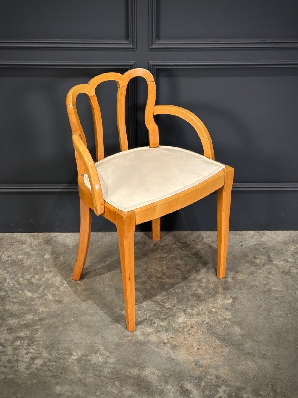 An Art Deco satinwood armchair featuring a triple-arched back rest, curved sweeping arms, a light cream upholstered seat pad, and tapered legs. View II