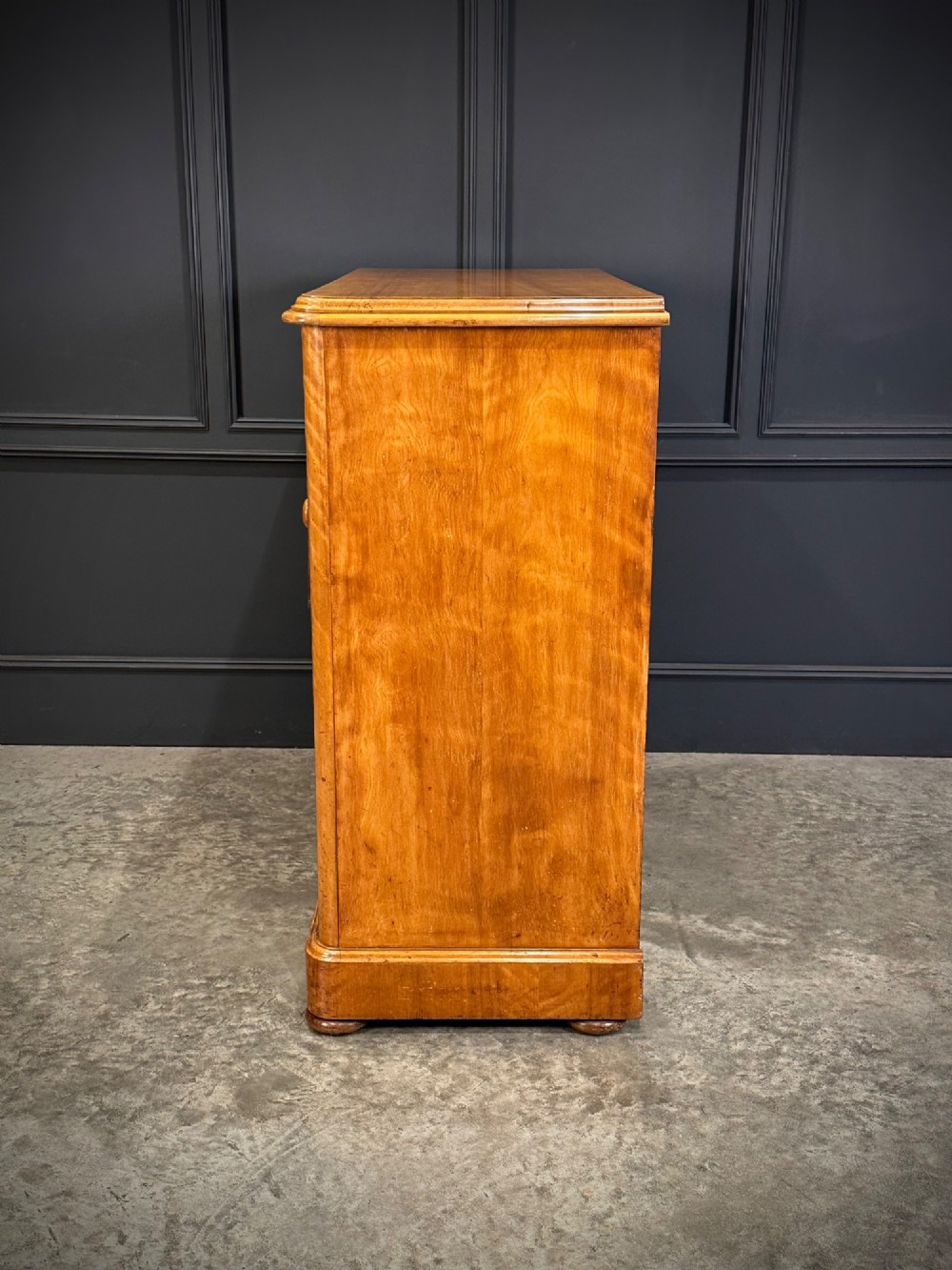 A Victorian satinwood chest of drawers featuring two short drawers over three long drawers with turned wooden knobs and a solid plinth base. View VIII
