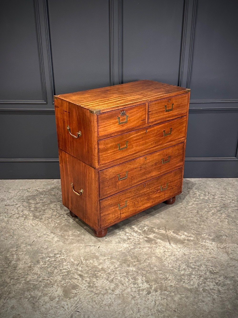 A Victorian two-part mahogany military campaign chest featuring flush brass handles, brass corner mounts, and turned bun feet. View II