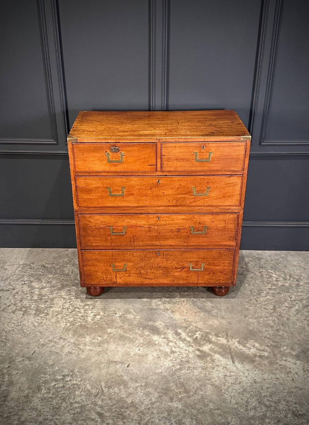 A Victorian two-part mahogany military campaign chest featuring flush brass handles, brass corner mounts, and turned bun feet. View III
