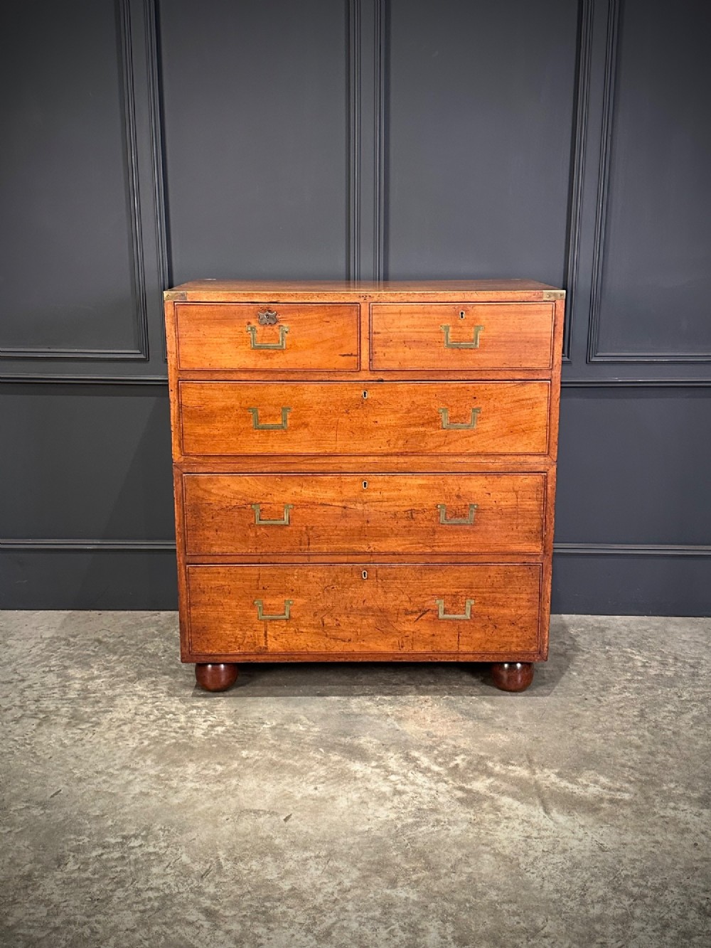 A Victorian two-part mahogany military campaign chest featuring flush brass handles, brass corner mounts, and turned bun feet. View IV