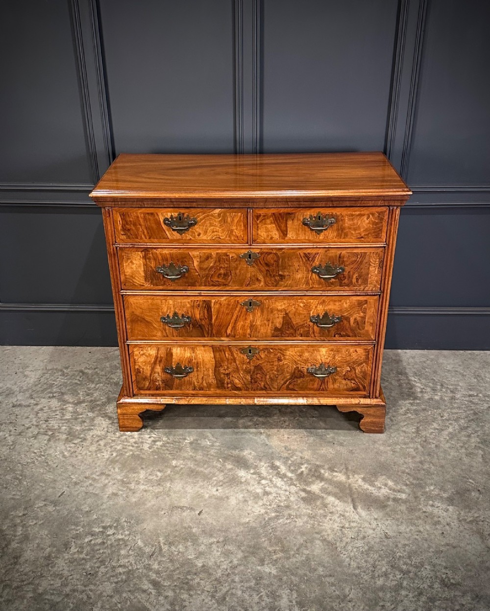 An 18th-century walnut chest of drawers featuring two short drawers over three long drawers, brass handles, and bracket feet. View III