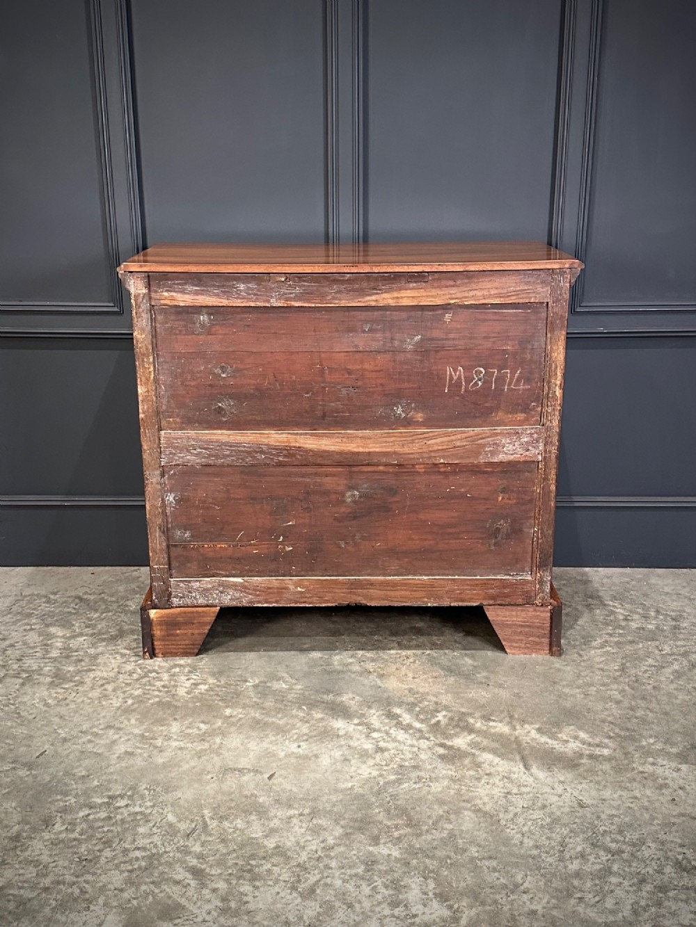 An 18th-century walnut chest of drawers featuring two short drawers over three long drawers, brass handles, and bracket feet. View VIII