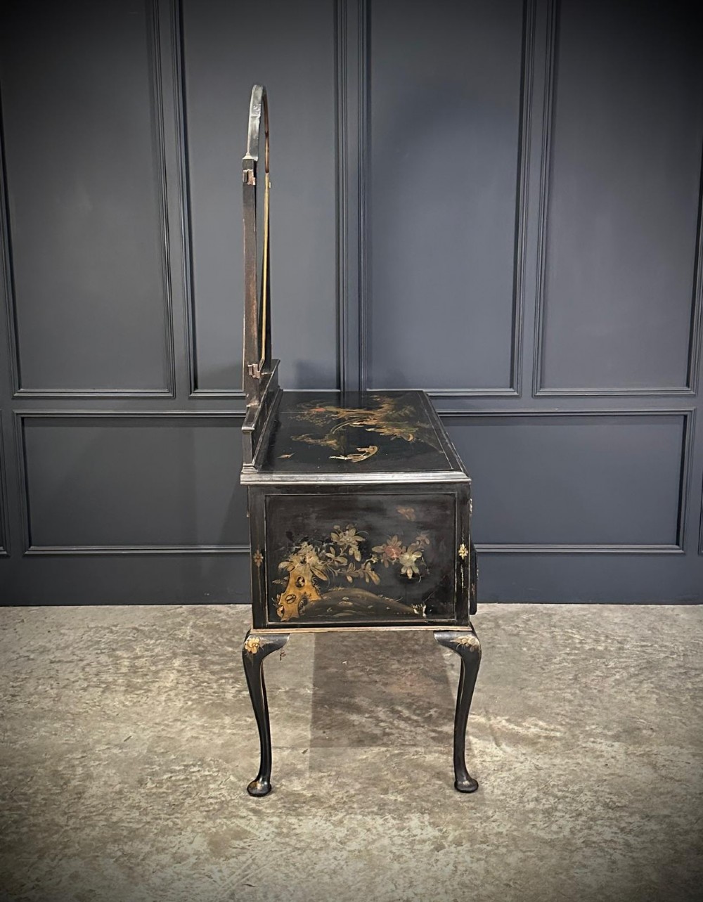 A black lacquered Chinoiserie dressing table featuring gilt hand-painted figures and landscapes, five drawers, cabriole legs, and an arched mirror attached to the top. View VI