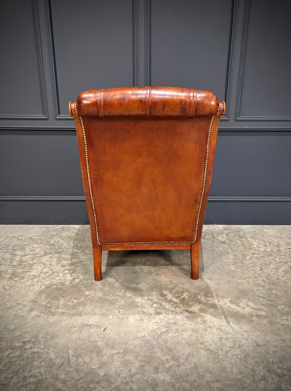 A pair of antique oak armchairs upholstered in deep-buttoned chestnut brown leather with turned front legs and brass castors. View XII