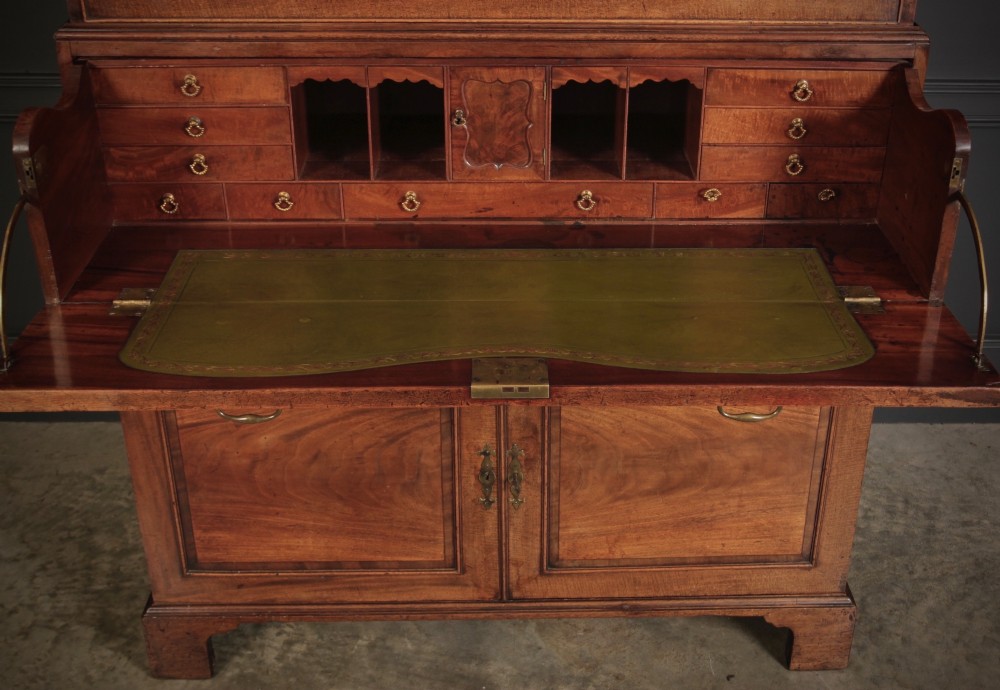 An 18th-century Georgian flame mahogany tallboy chest on chest featuring brass handles, upper drawers, and lower cupboard doors. View IV