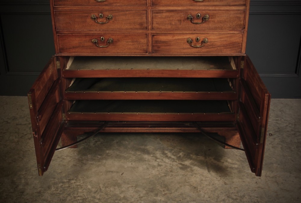 An 18th-century Georgian flame mahogany tallboy chest on chest featuring brass handles, upper drawers, and lower cupboard doors. View VI