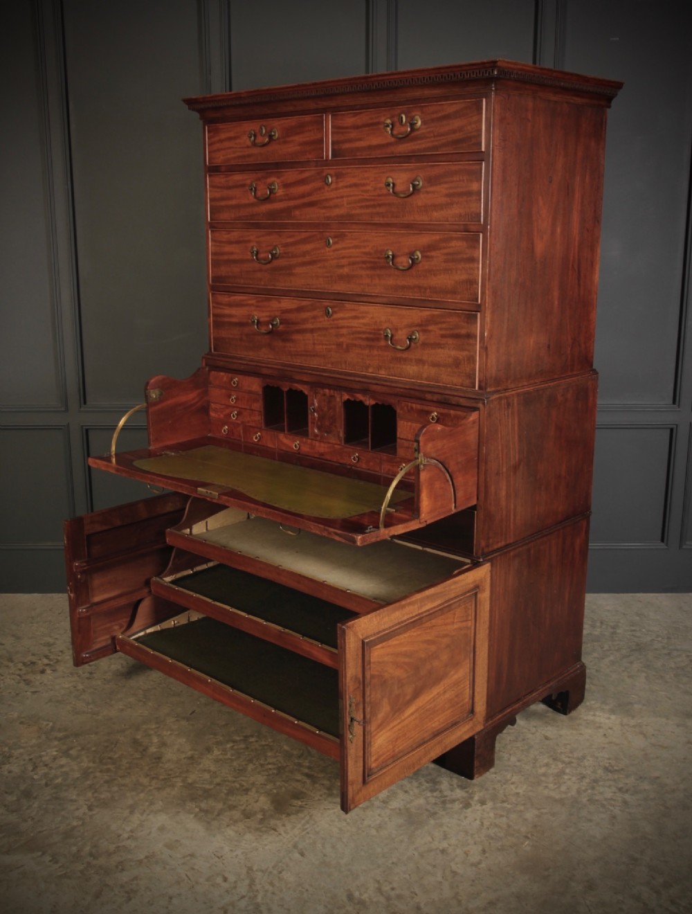 An 18th-century Georgian flame mahogany tallboy chest on chest featuring brass handles, upper drawers, and lower cupboard doors. View VII