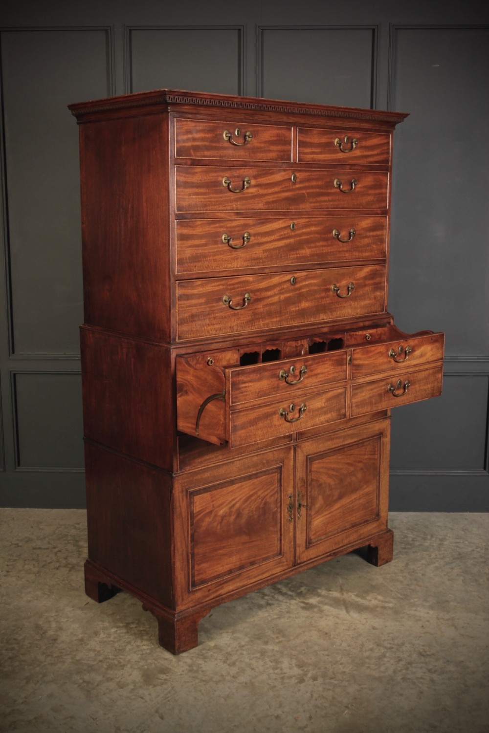 An 18th-century Georgian flame mahogany tallboy chest on chest featuring brass handles, upper drawers, and lower cupboard doors. View IX