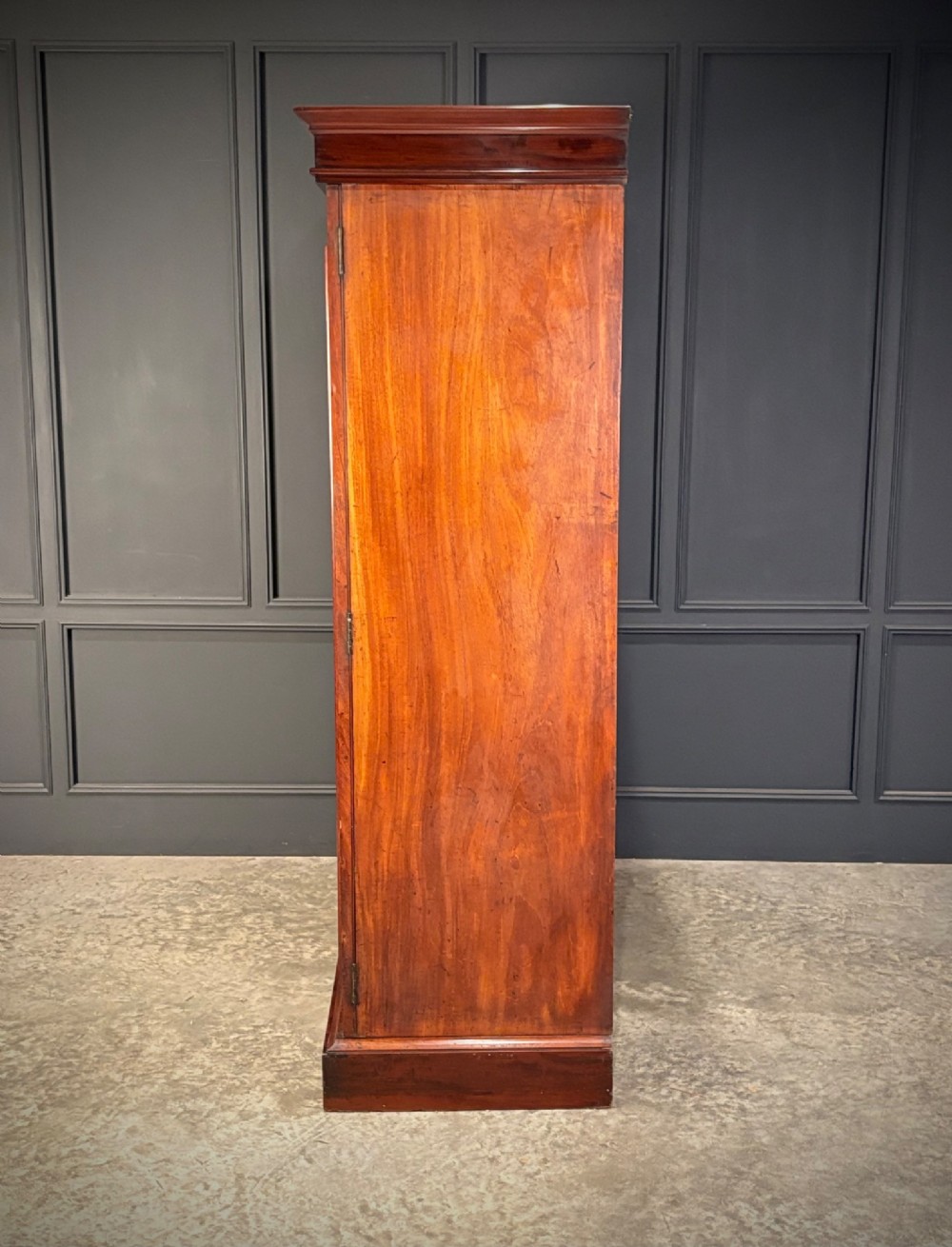 A two-door William IV mahogany wardrobe featuring flame mahogany panels, a moulded top cornice, and a sturdy plinth base. View IV