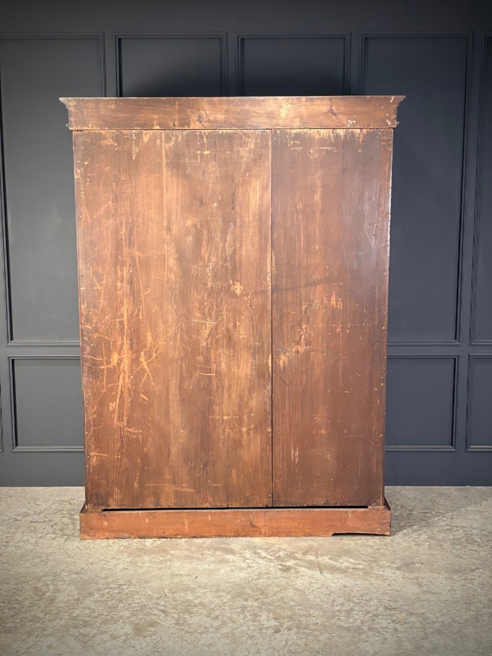 A two-door William IV mahogany wardrobe featuring flame mahogany panels, a moulded top cornice, and a sturdy plinth base. View V