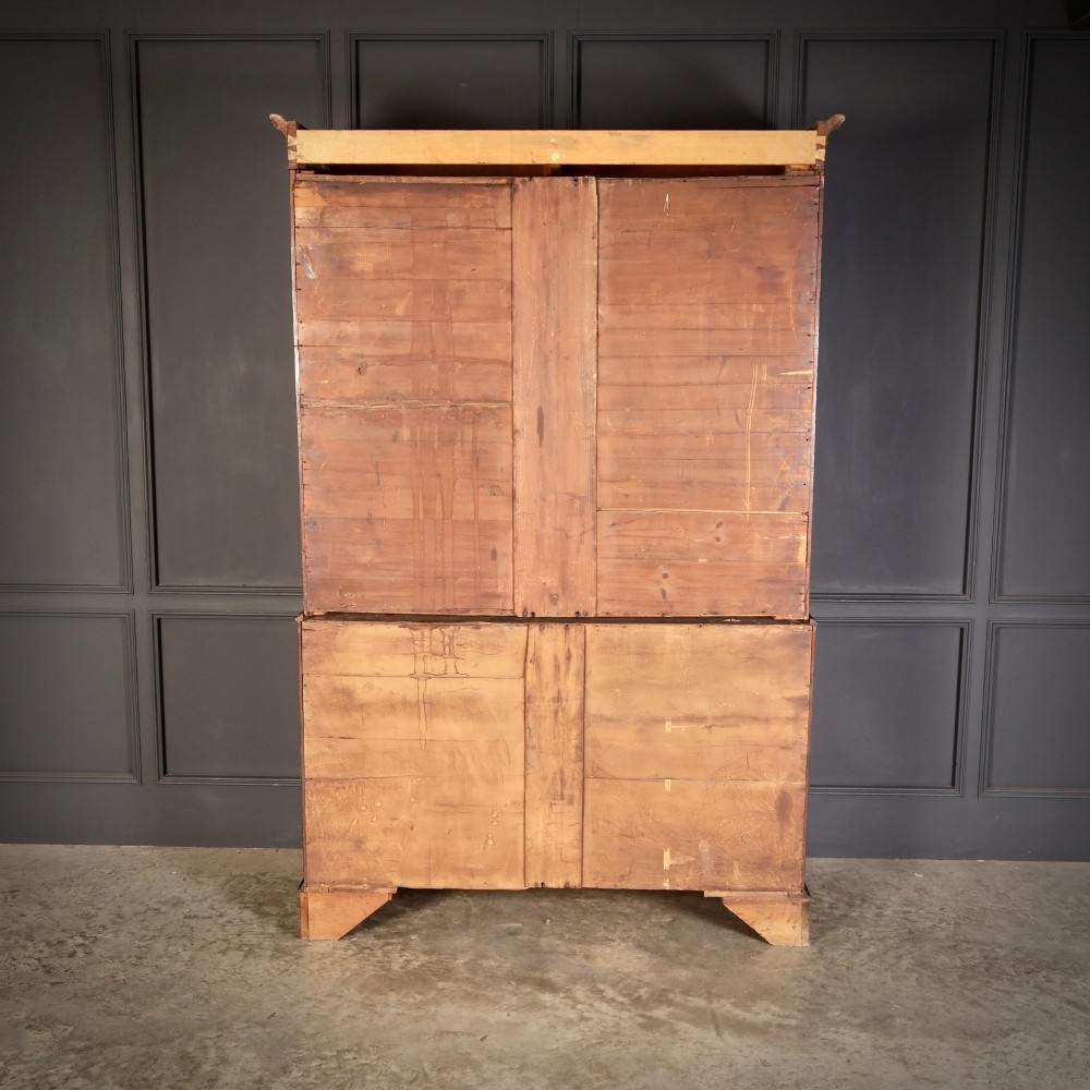 A Georgian mahogany linen press featuring botanical marquetry inlay on upper double doors over four lower drawers with brass handles. View IX